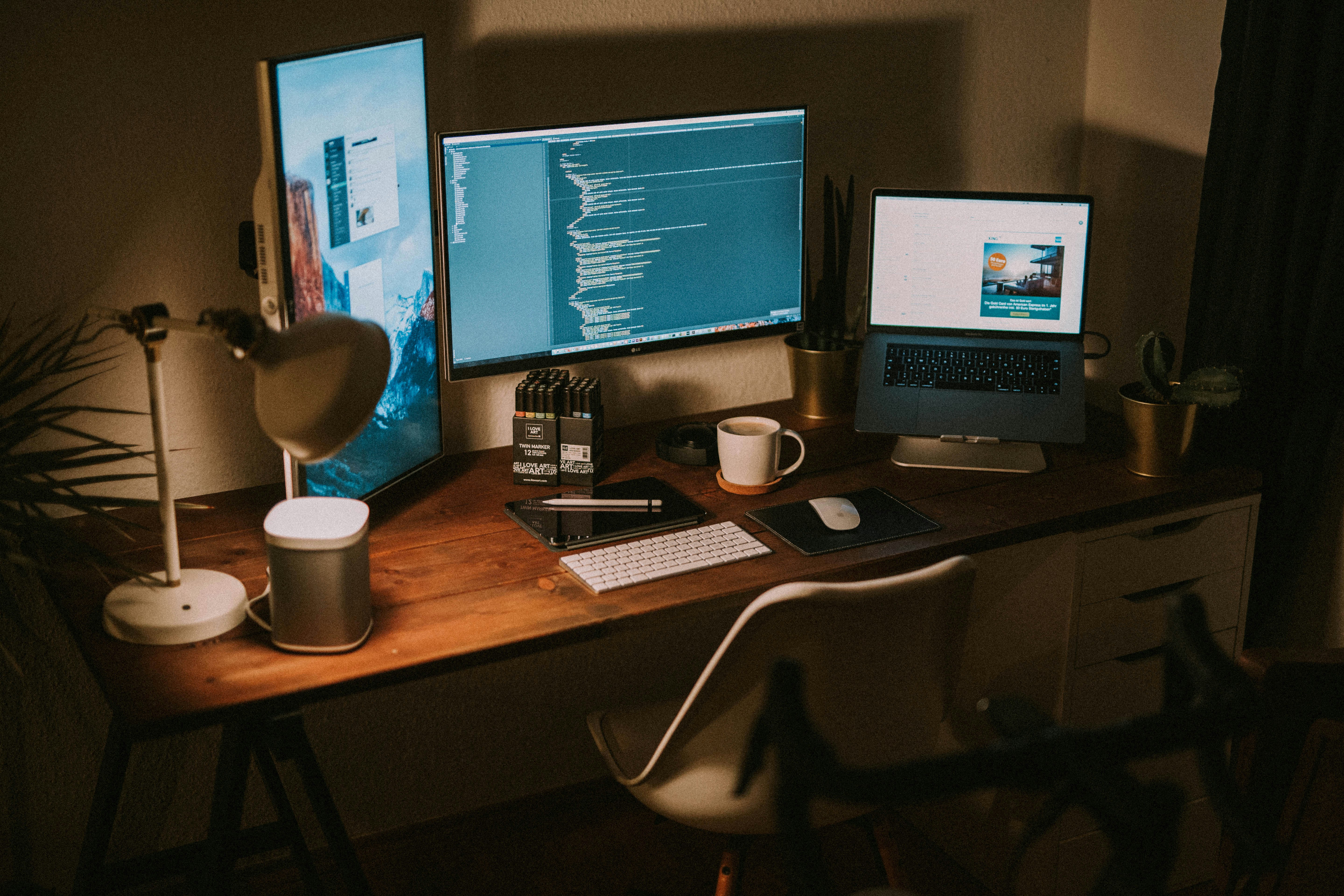 Desk with a laptop, books and a lit candle